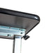 Close-up view of an overbed table's height adjustment lever in the locked position, showing the wooden tabletop surface and steel base construction
