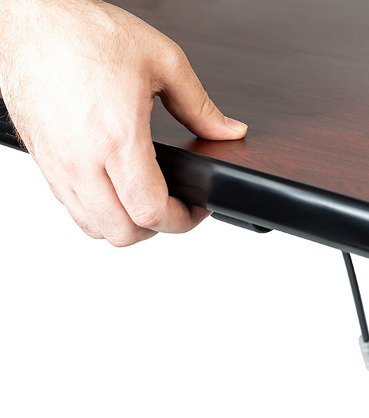 Hand gripping black table edge handle for easy lifting or height adjustment of tilt top dining table