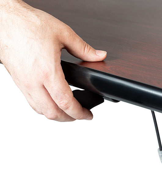 Hand positioning on black pneumatic adjustment hardware along table edge