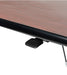 Wood grain tabletop edge detail showing black trim border and pneumatic adjustment hardware underneath table surface