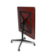 Square tilt top dining table angled view featuring Mahogany wood grain top with black X-pattern support frame and rolling casters