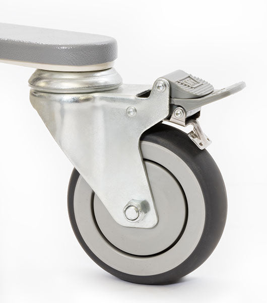 A close-up of a gray and black swivel caster with metal bracket and foot brake, designed for the Free Spirit Bariatric Patient Lift FS660-T (660 lb capacity), shown against a white background.
