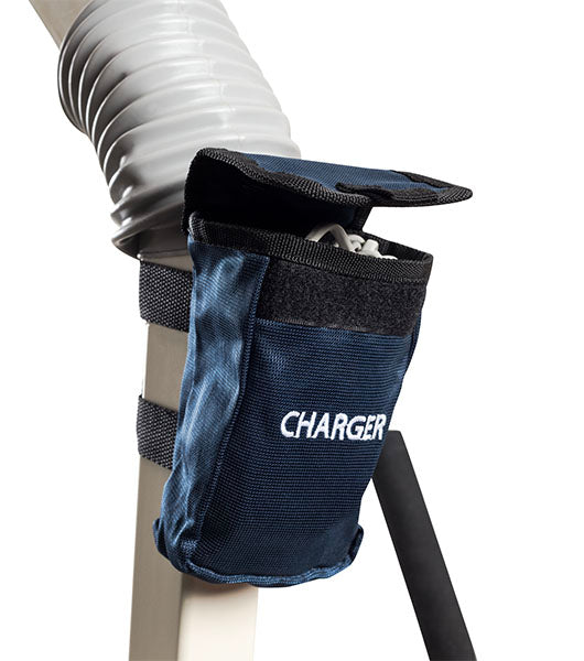 A blue fabric pouch labeled CHARGER is attached with Velcro straps to the white tube of the Free Spirit Bariatric Patient Lift FS660-T. The open flap reveals a charging cable inside.