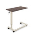 Overbed table for assisted living furniture featuring Mahogany surface with white height-adjustable base and four-wheel caster system