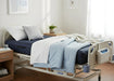 Protekt Aire 6450 air mattress system on hospital bed, with pillows, blankets, and control unit at the foot of the bed