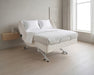 Supernal 5 adjustable hospital bed in a minimalist room with a window and wooden side table.