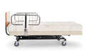 Transfer Master Supernal 3 hospital bed with chrome half rails and cherry headboard in flat position, side view